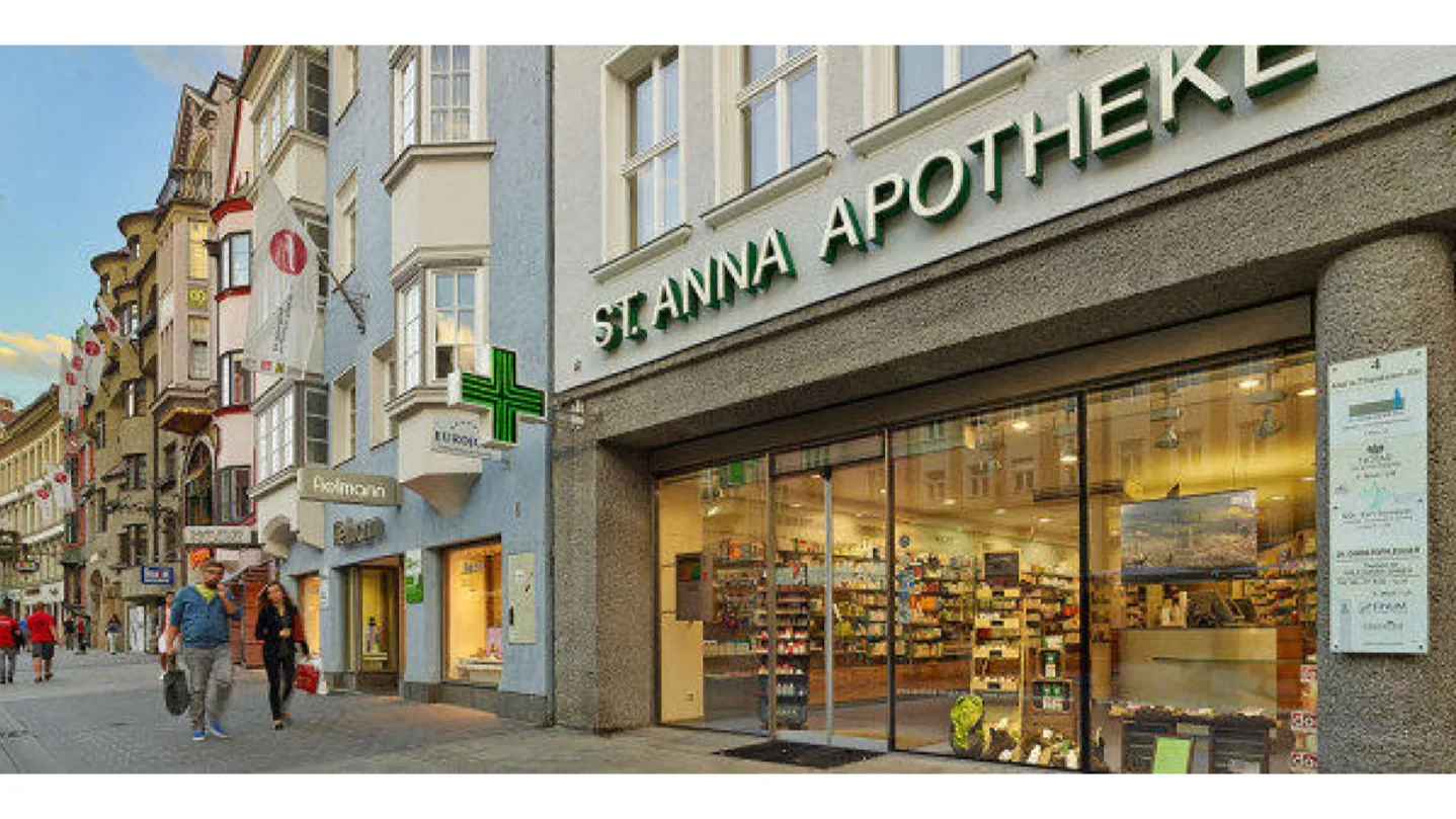 Eingang der St. Anna-Apotheke in der Maria-Theresien-Straße in Innsbruck mit Leuchtschrift und grünem Apothekenkreuz